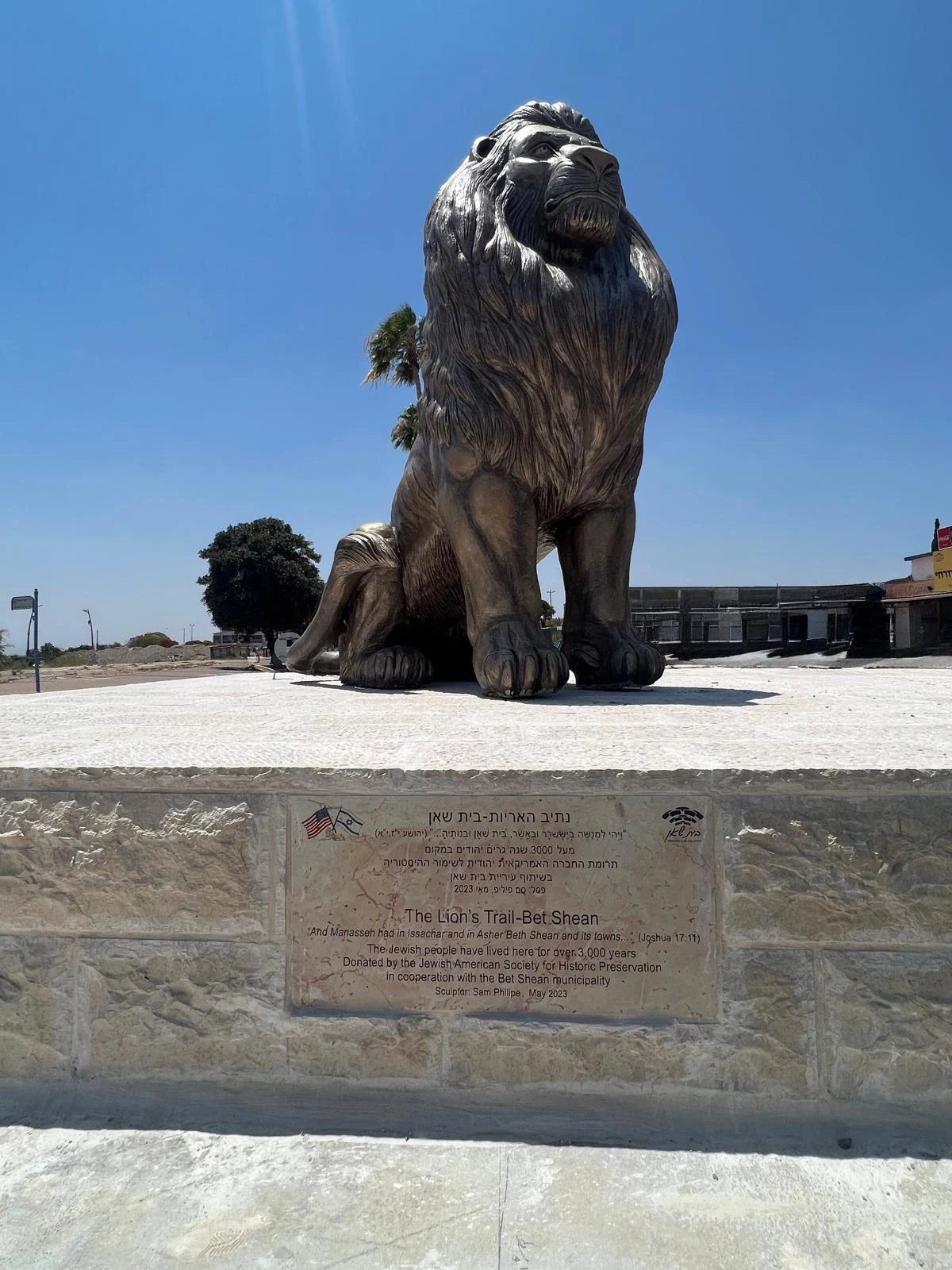 אריה בית שאן של סם פיליפ יושב על בסיס אבן עם לוח הקדשה בכניסה הצפונית לעיר