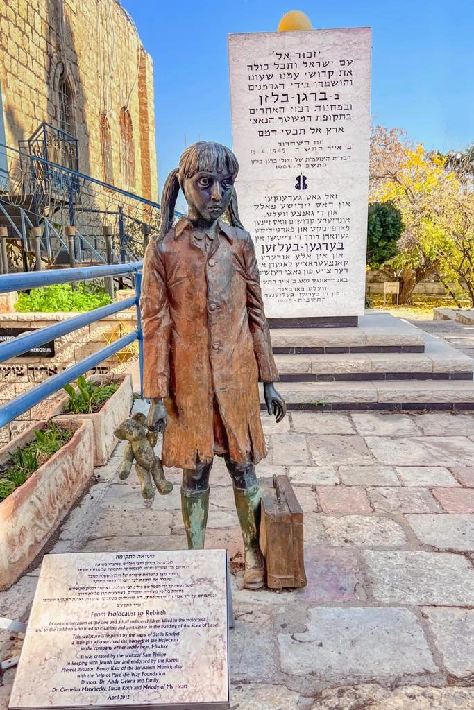 משואה לתקומה — ילדה מברונזה עם דובי ומזוודה, לצד לוח הקדשה בהר ציון