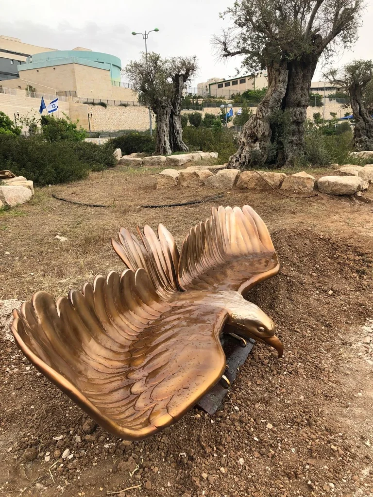 פסל הבז האדום של סם פיליפ, עוף דורס בעל כנפיים פרושות בנקודת התצפית בנופי סלע