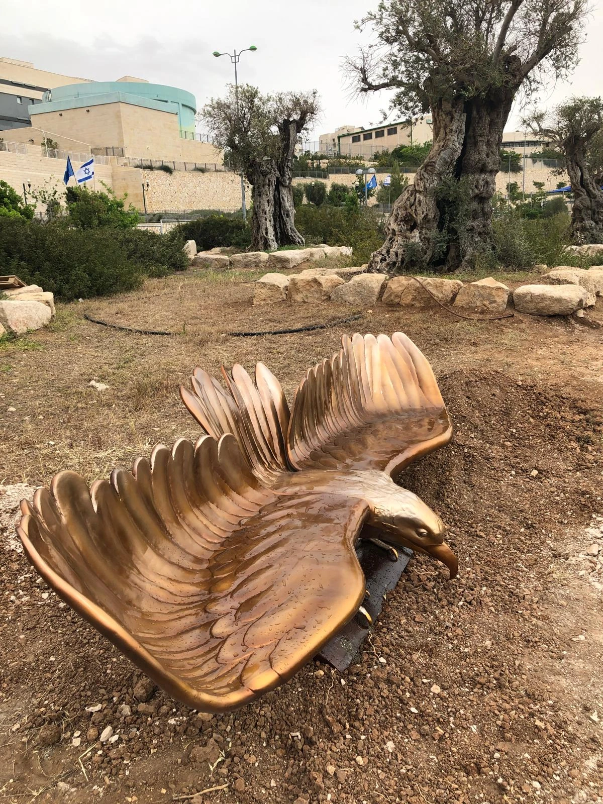 פסל הבז האדום של סם פיליפ, עוף דורס בעל כנפיים פרושות בנקודת התצפית בנופי סלע