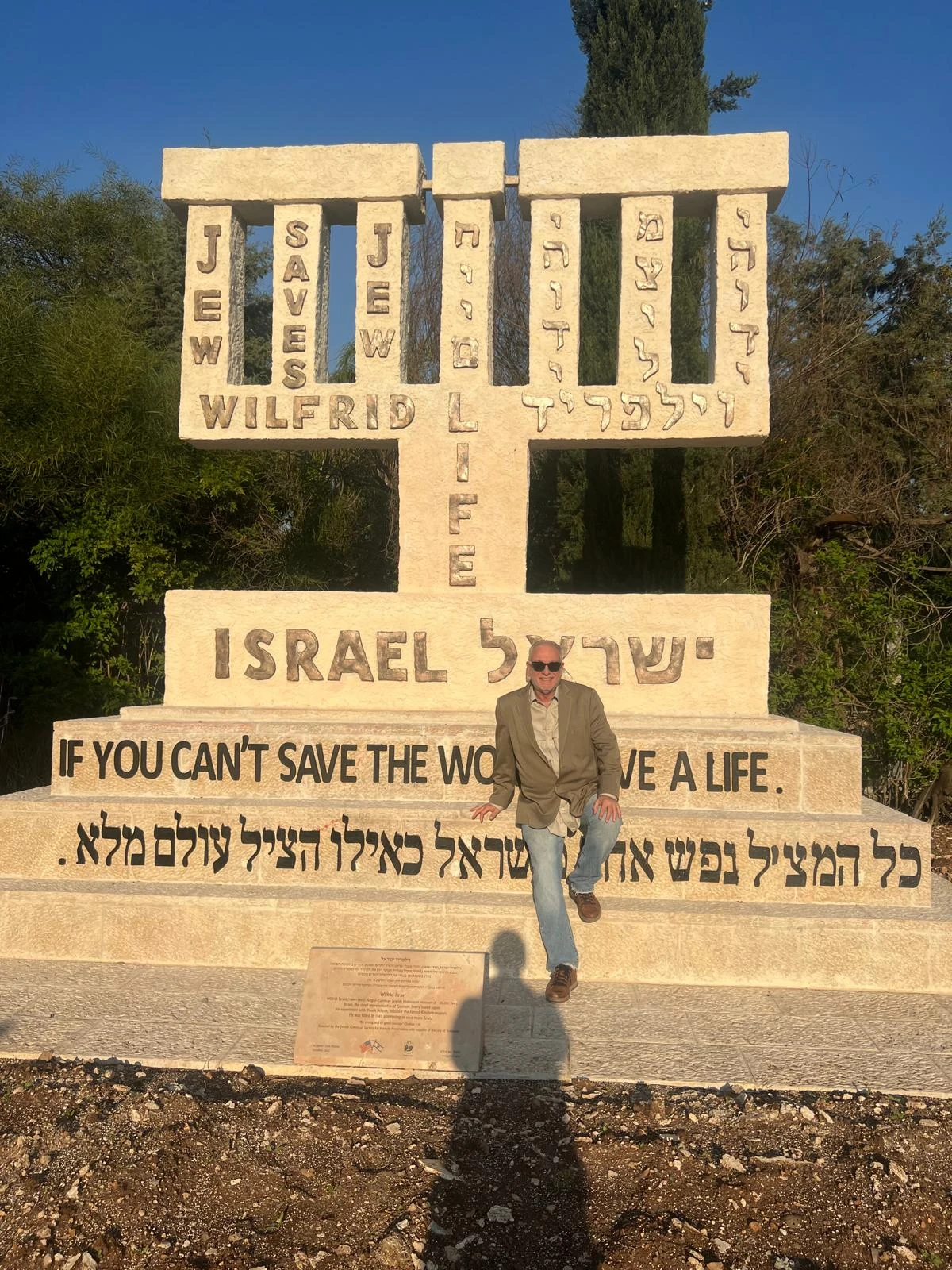 מנורת וילפריד ישראל עם כתובות בעברית ובאנגלית וסם פיליפ לצדה